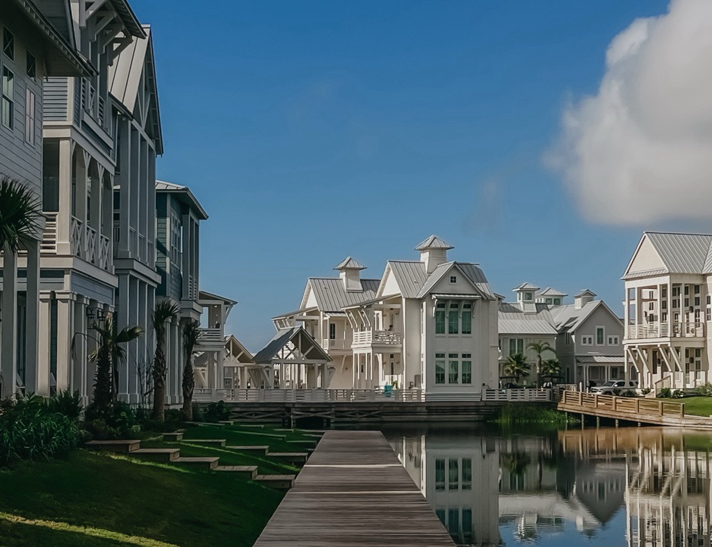 Cinnamon Shore - a body of water with a walkway leading to a row of white buildings